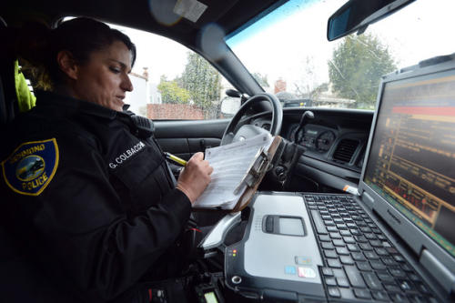 Richmond police Officer Giulia Colbacchini logs her activity as she patrols in Richmond Feb. 19, 2013.